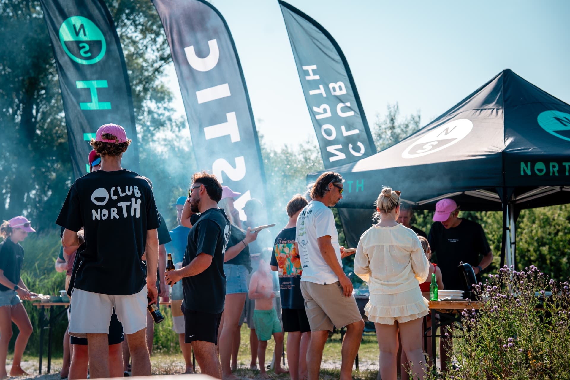 Wijds shot van de strand-BBQ met vlaggen en tenten