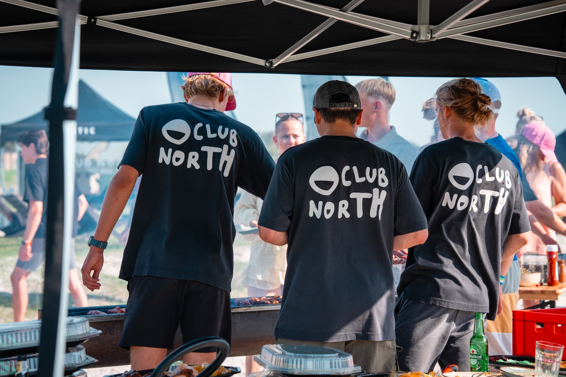 Crew werkt aan de BBQ onder een tent