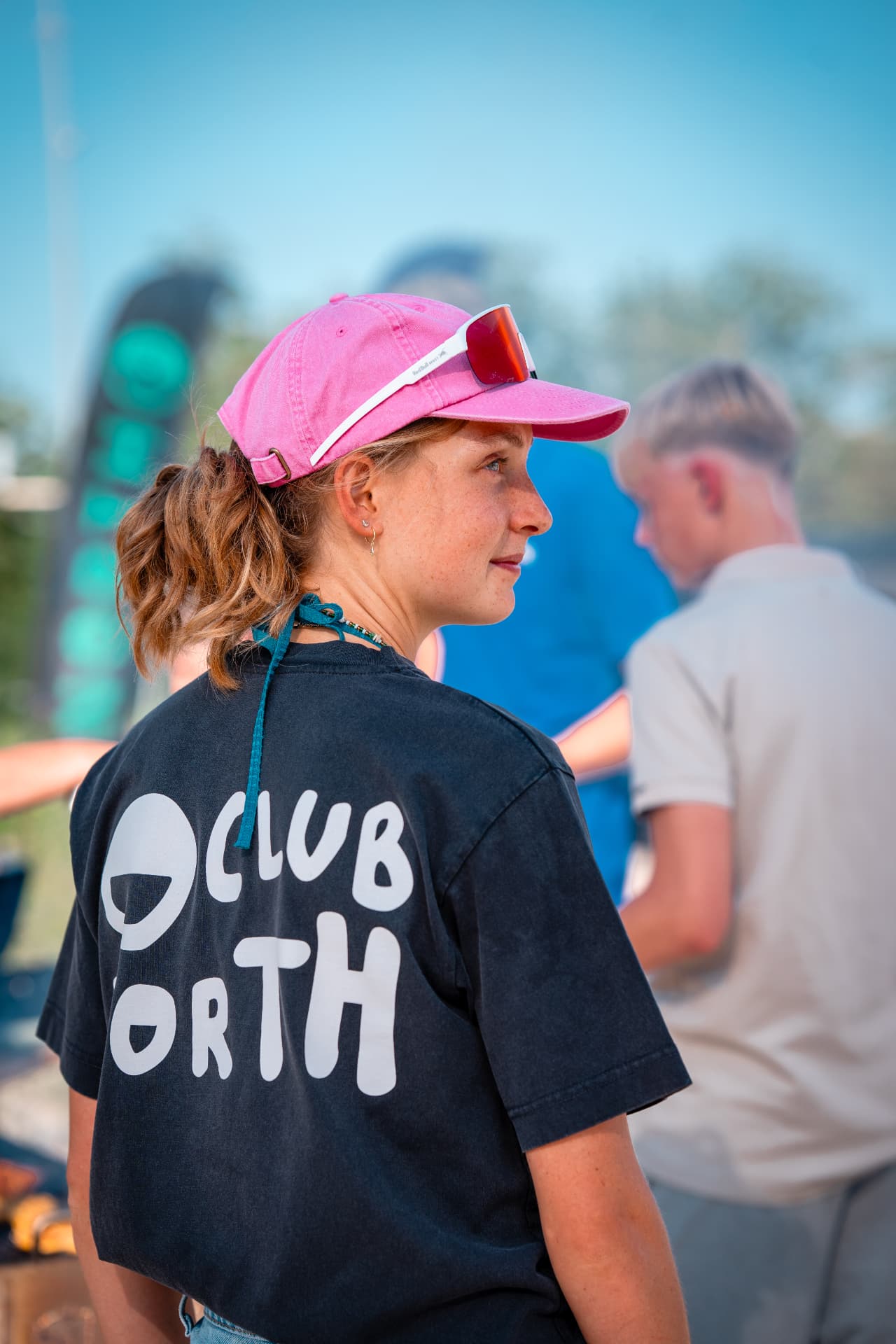 Portret van een vrouw in een roze pet en Club North-shirt